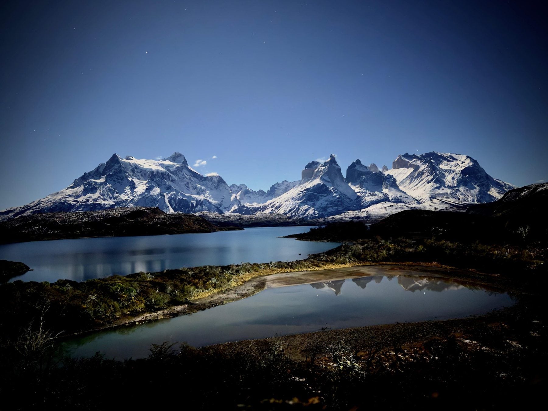 Torres del Paine de noche, lago y macizo bajo la luna